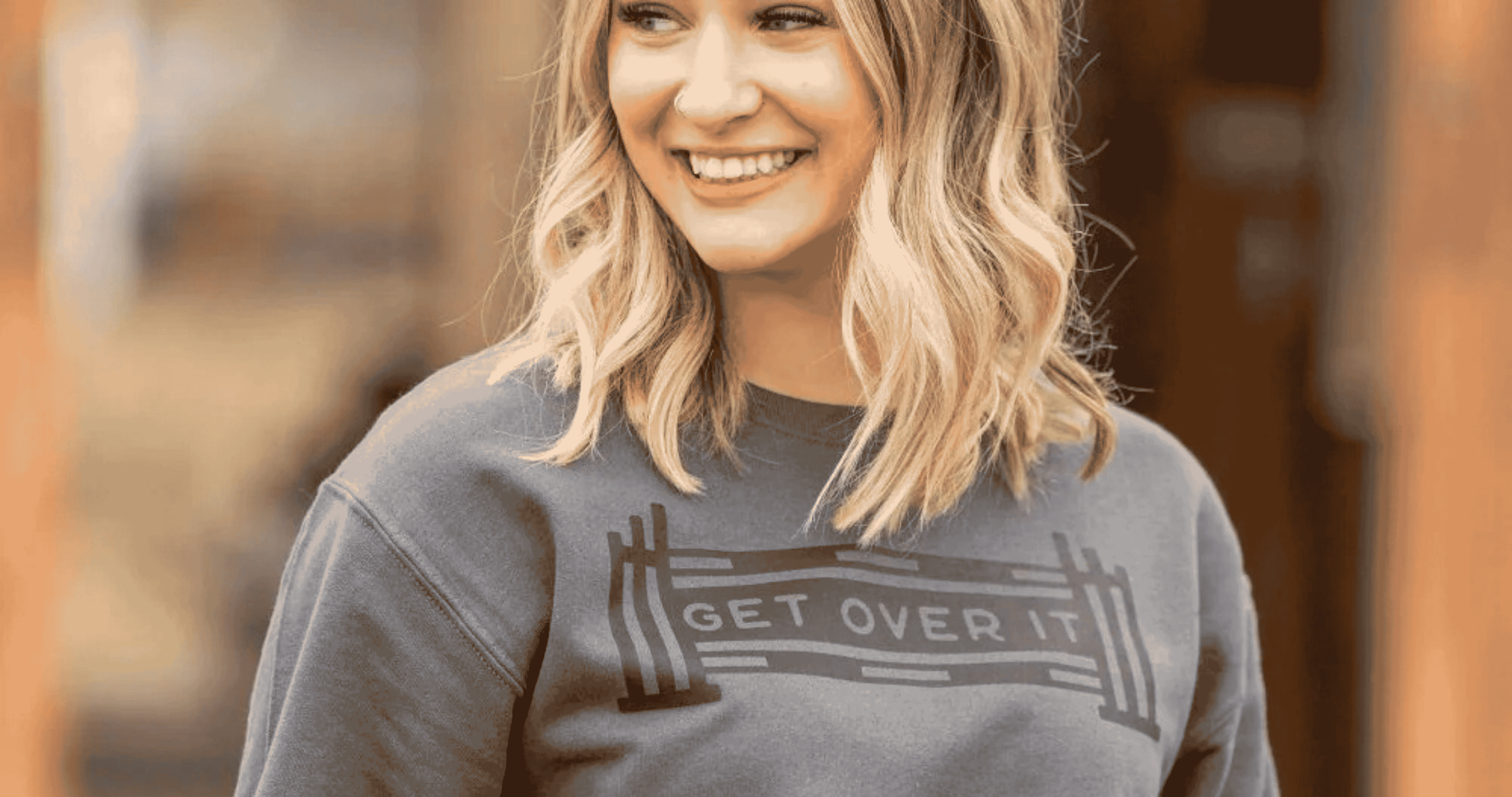 blonde woman looking off to the left wearing Dapplebay sweatshirt. Horse equipment, horse gear