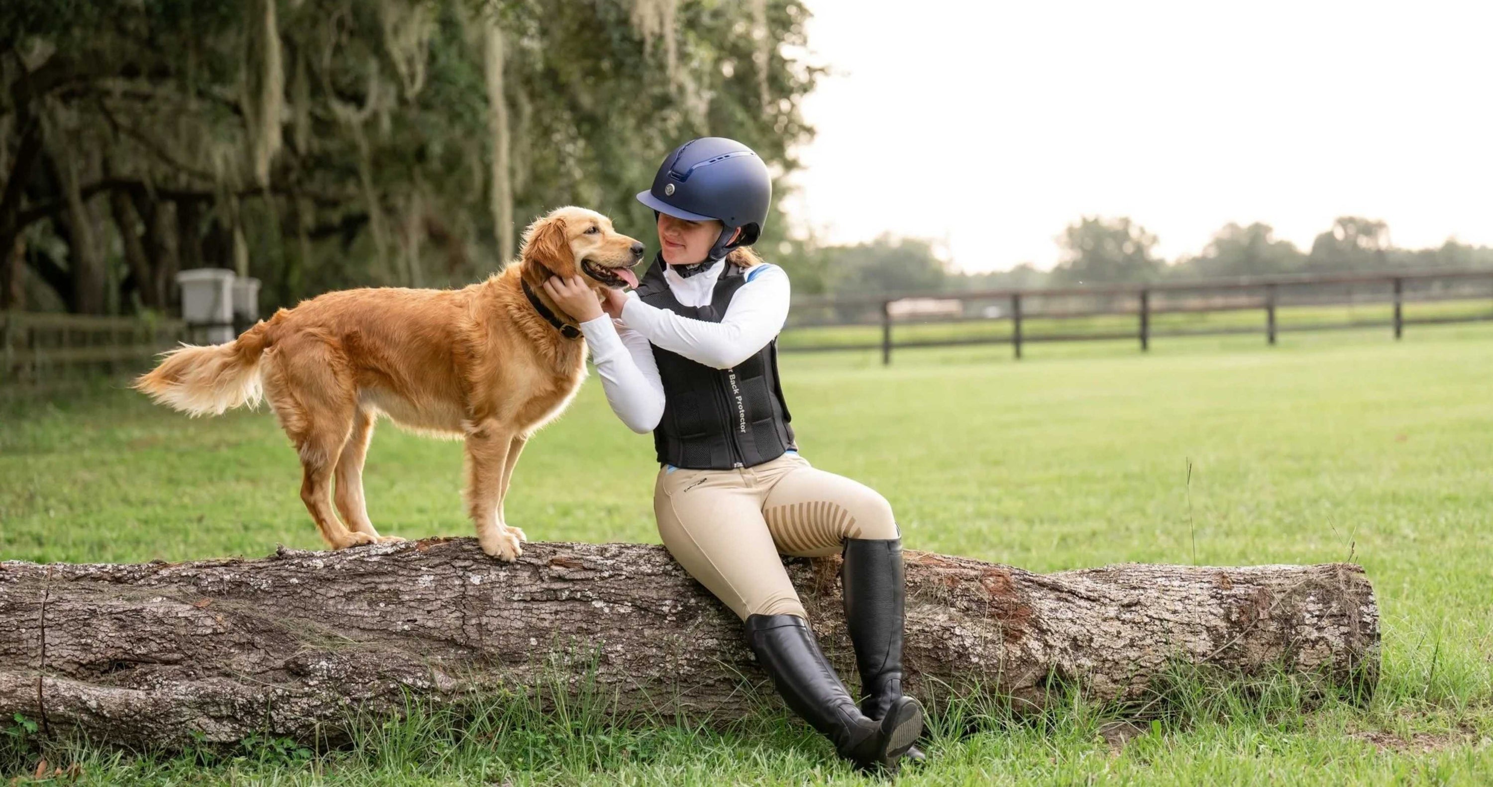 girl wearing TuffRider horse riding helmet sits on a log in a green field with golden retriever, horse riding helmets, rider helmets, Tuffrider helmet
