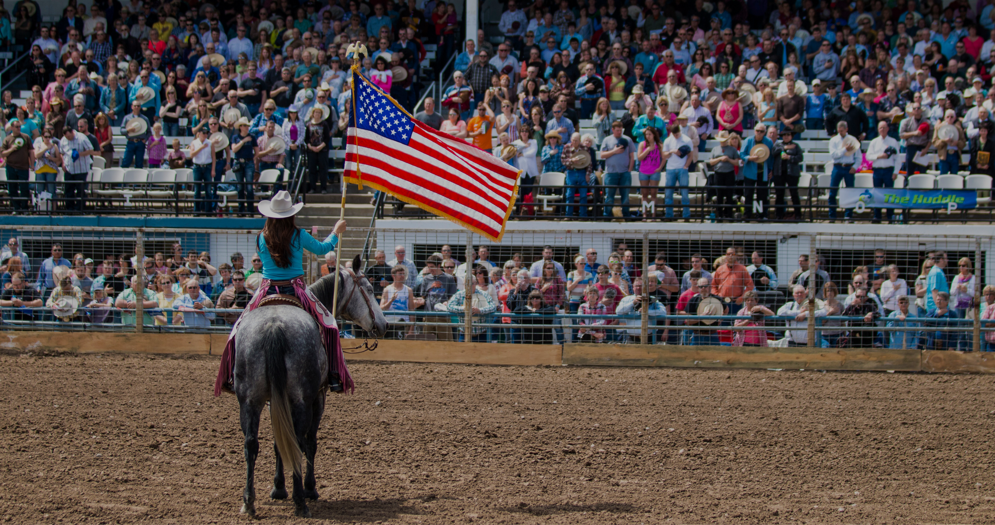woman flying american flag at the rodeo