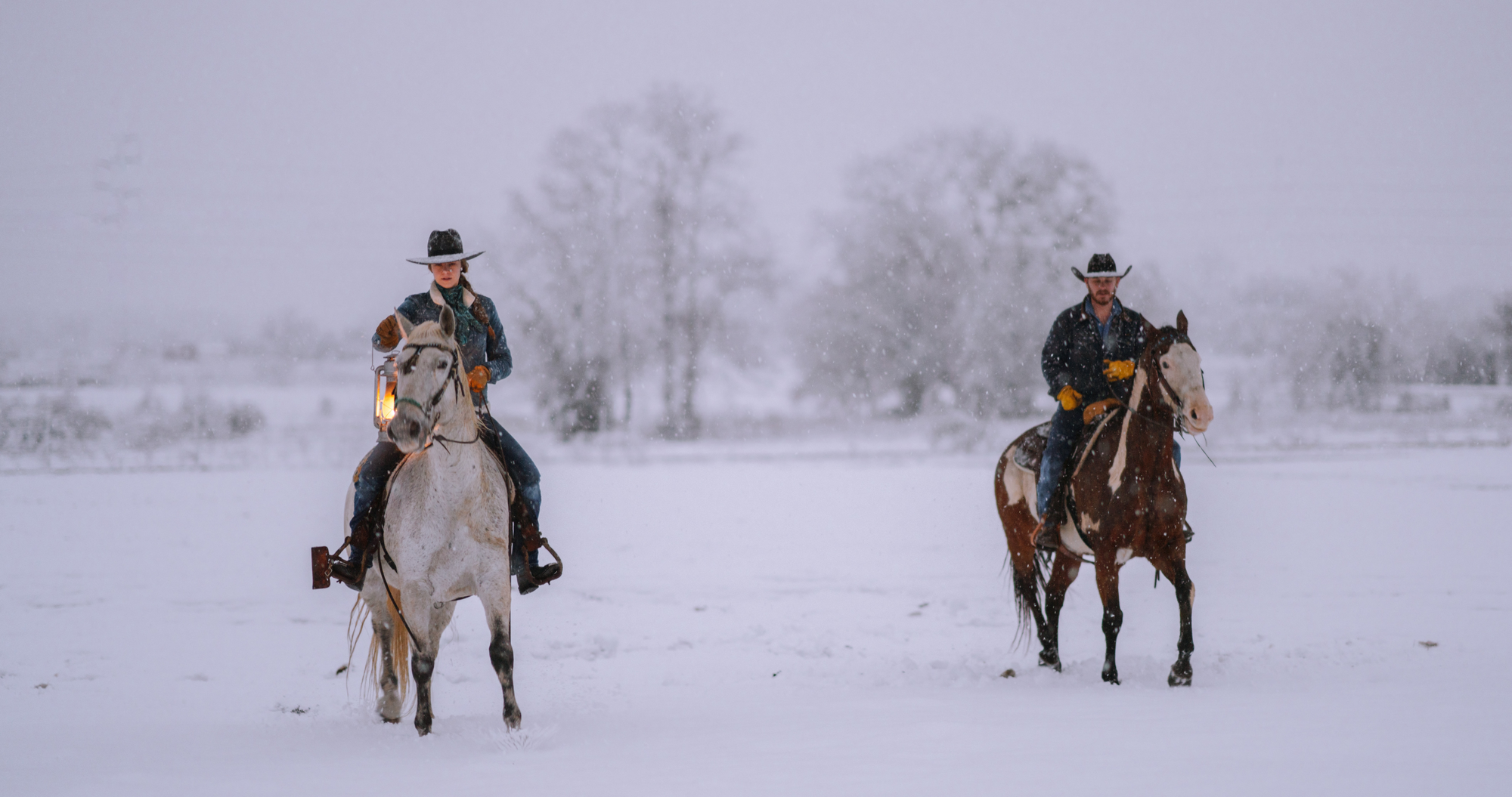 two western riders on a winter trail riding expedition